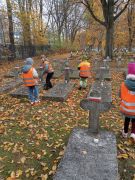 Dzieci stawiają znicze 