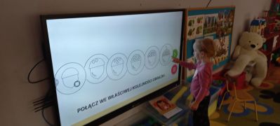 dziewczynka układa żołędzie wg kolejności na tablicy multimedialnej