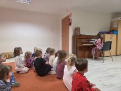 Dzieci słuchają gry na pianinie